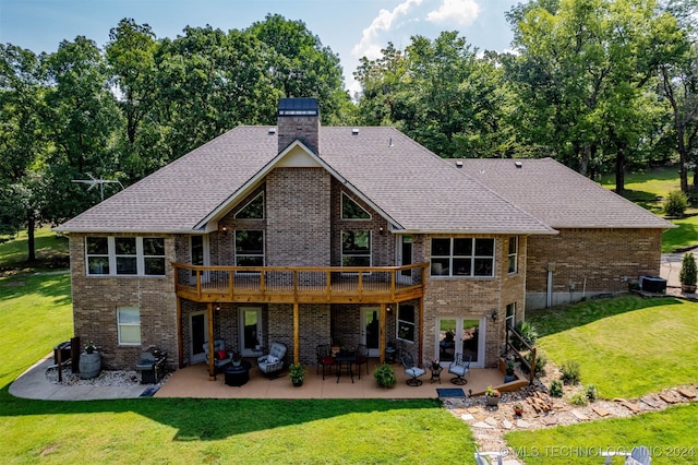 rear view of property featuring a patio, a wooden deck, and a lawn