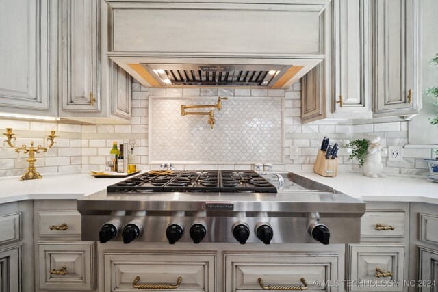 kitchen featuring tasteful backsplash, stainless steel gas cooktop, and premium range hood