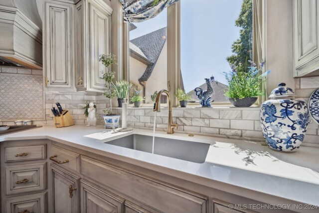 kitchen featuring a wealth of natural light, sink, and backsplash