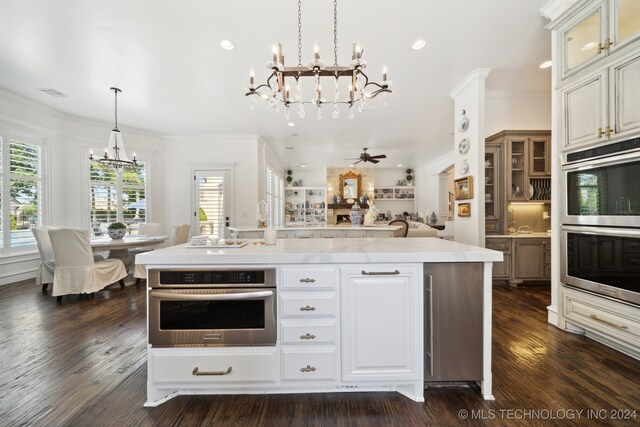 kitchen featuring a center island, ornamental molding, double oven, dark hardwood / wood-style floors, and pendant lighting