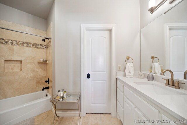 bathroom with tile patterned floors, vanity, and tiled shower / bath