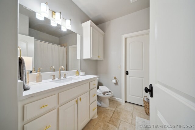 bathroom with toilet, tile patterned flooring, and vanity