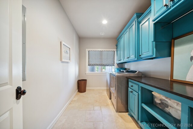 laundry room featuring light tile patterned floors, separate washer and dryer, and cabinets