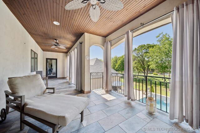 sunroom / solarium with ceiling fan and wooden ceiling