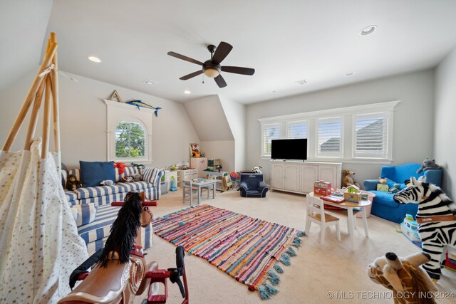 living room with a wealth of natural light, ceiling fan, and light carpet