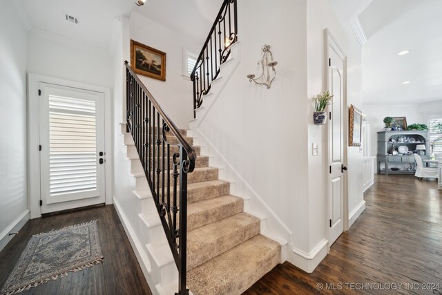 stairs with ornamental molding and wood-type flooring