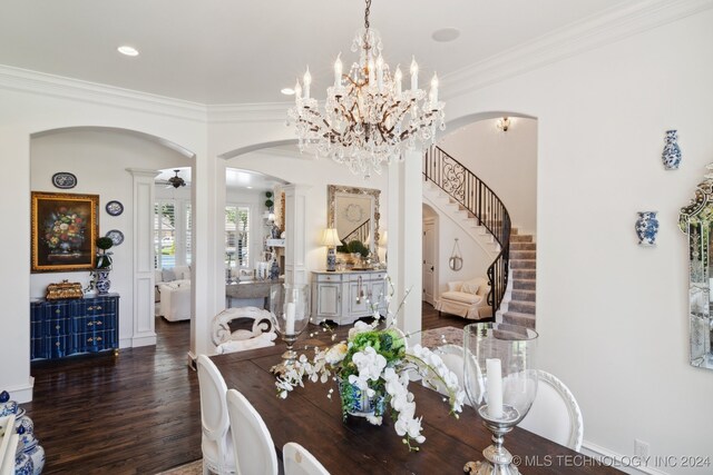 dining space with dark hardwood / wood-style floors, crown molding, and an inviting chandelier