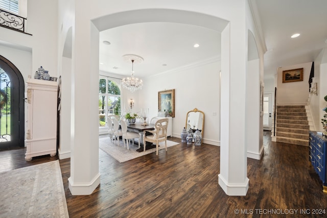 foyer featuring a notable chandelier, crown molding, and dark wood-type flooring