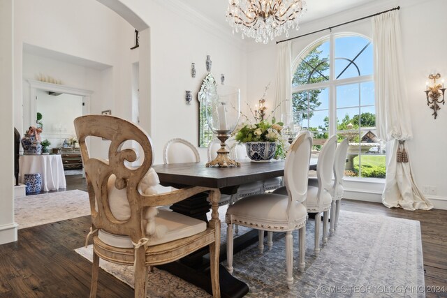 dining room with a notable chandelier, dark wood-type flooring, and crown molding