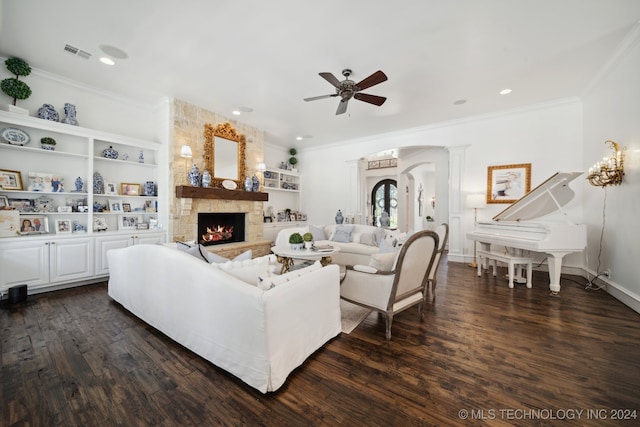 living room featuring ceiling fan, wood-type flooring, ornamental molding, and a fireplace