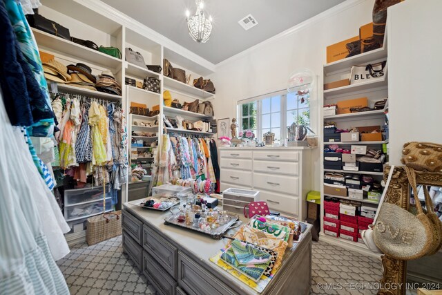 spacious closet with light carpet and a chandelier