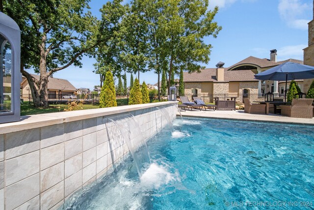 view of pool with a patio and pool water feature