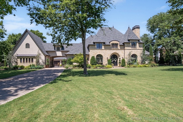 french country inspired facade with a front lawn