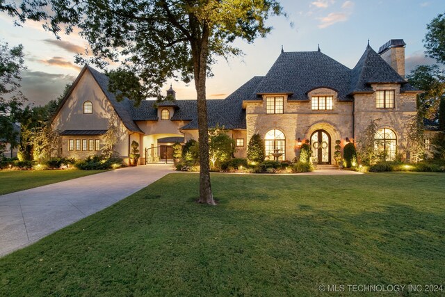 french provincial home with a lawn