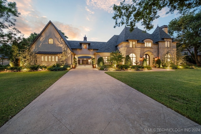 french country inspired facade featuring a lawn