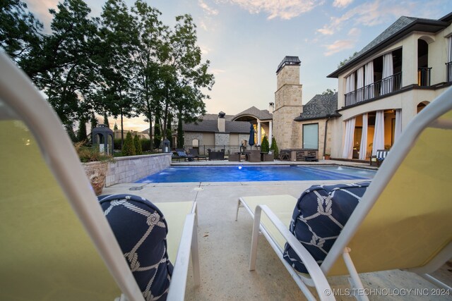 pool at dusk with a patio