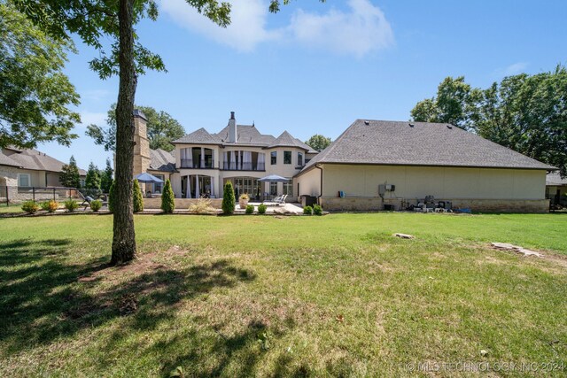 back of house featuring a patio and a yard