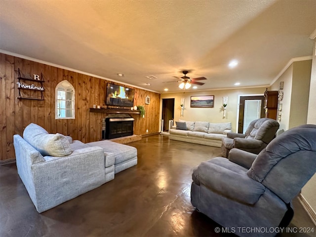 living room featuring wood walls, ceiling fan, and crown molding