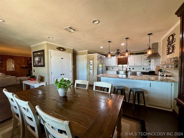 dining room featuring a textured ceiling and ornamental molding