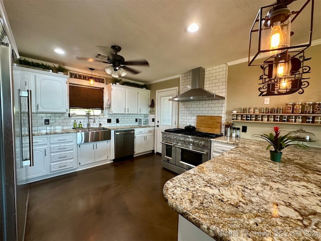 kitchen featuring ceiling fan, decorative backsplash, wall chimney exhaust hood, white cabinetry, and stainless steel appliances