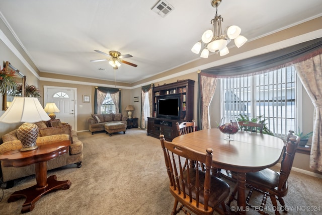 dining room with ornamental molding, ceiling fan with notable chandelier, and light colored carpet