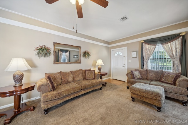 living room with ornamental molding, carpet floors, and ceiling fan