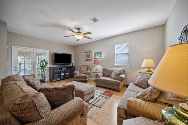 living room with ceiling fan and light hardwood / wood-style flooring