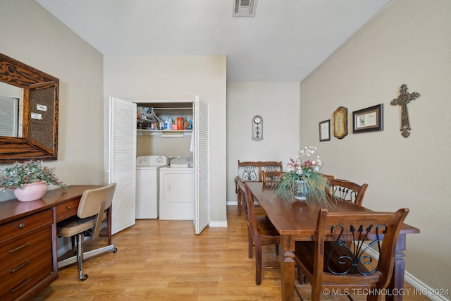 dining space with washer and dryer and light wood-type flooring