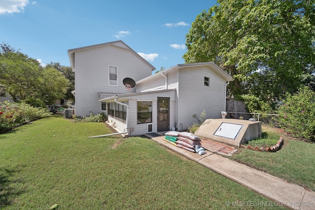 back of property featuring central AC, a sunroom, and a lawn