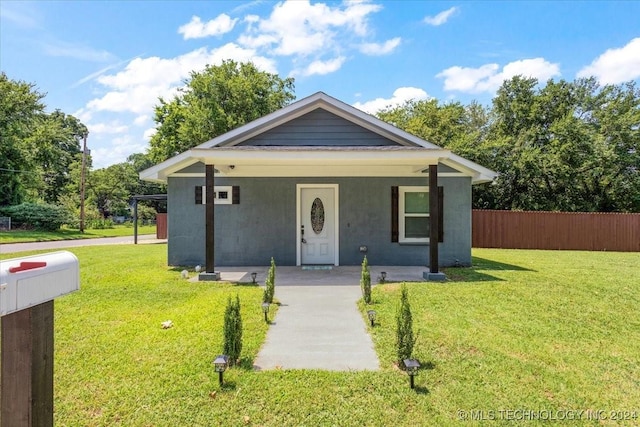 701 W Alabama, Durant, OK 74701 - bungalow-style home featuring stucco siding, a front lawn, fence, and covered porch