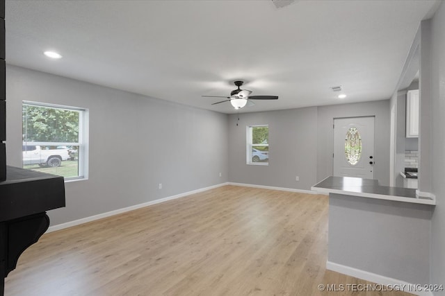 unfurnished living room with light hardwood / wood-style flooring and ceiling fan