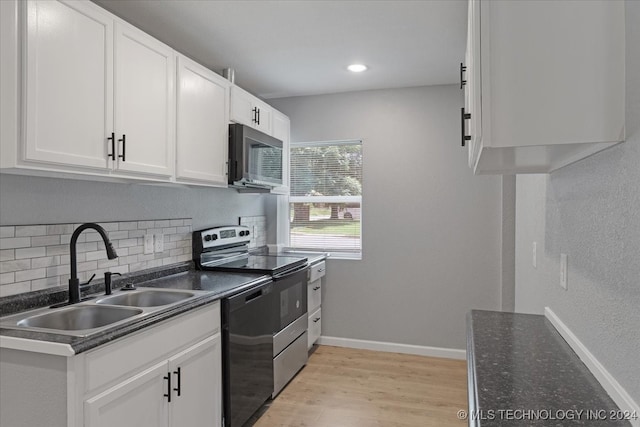 kitchen featuring sink, light hardwood / wood-style flooring, tasteful backsplash, black appliances, and white cabinets