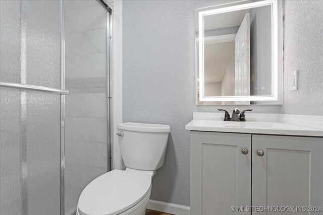 701 W Alabama, Durant, OK 74701 - full bathroom with toilet, a textured wall, vanity, and a stall shower