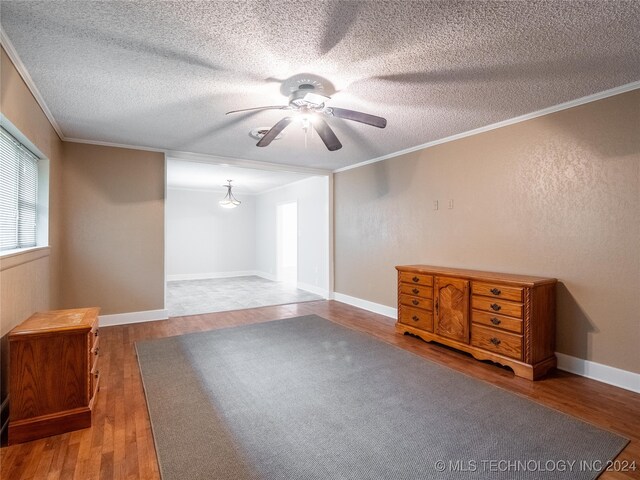 empty room featuring ceiling fan, hardwood / wood-style floors, and ornamental molding