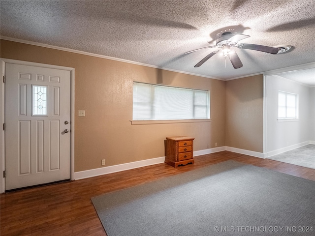 foyer entrance featuring hardwood / wood-style flooring, ceiling fan, ornamental molding, and a textured ceiling