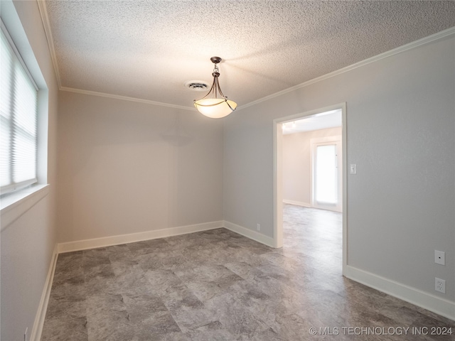 spare room featuring a healthy amount of sunlight, ornamental molding, and a textured ceiling