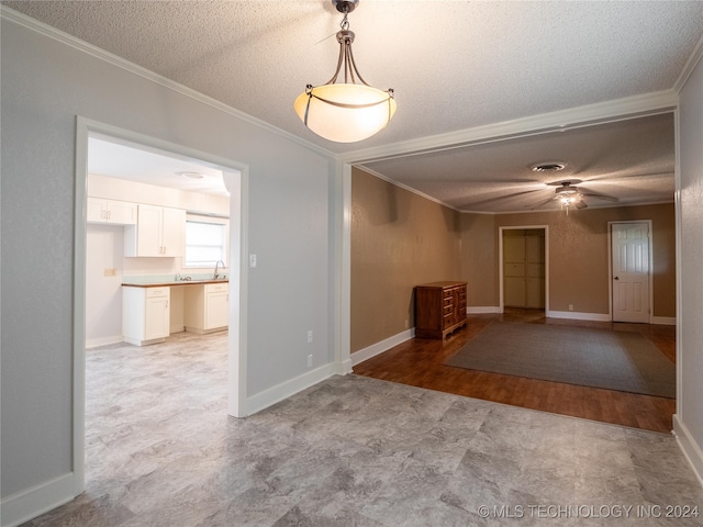 spare room featuring crown molding, light hardwood / wood-style flooring, and a textured ceiling