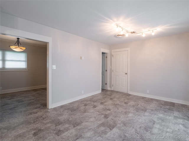 unfurnished room featuring rail lighting