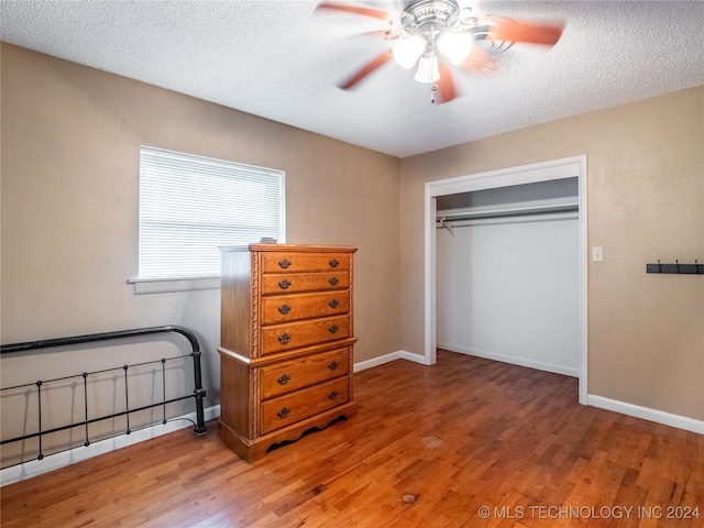 bedroom featuring ceiling fan, a closet, a textured ceiling, and hardwood / wood-style flooring