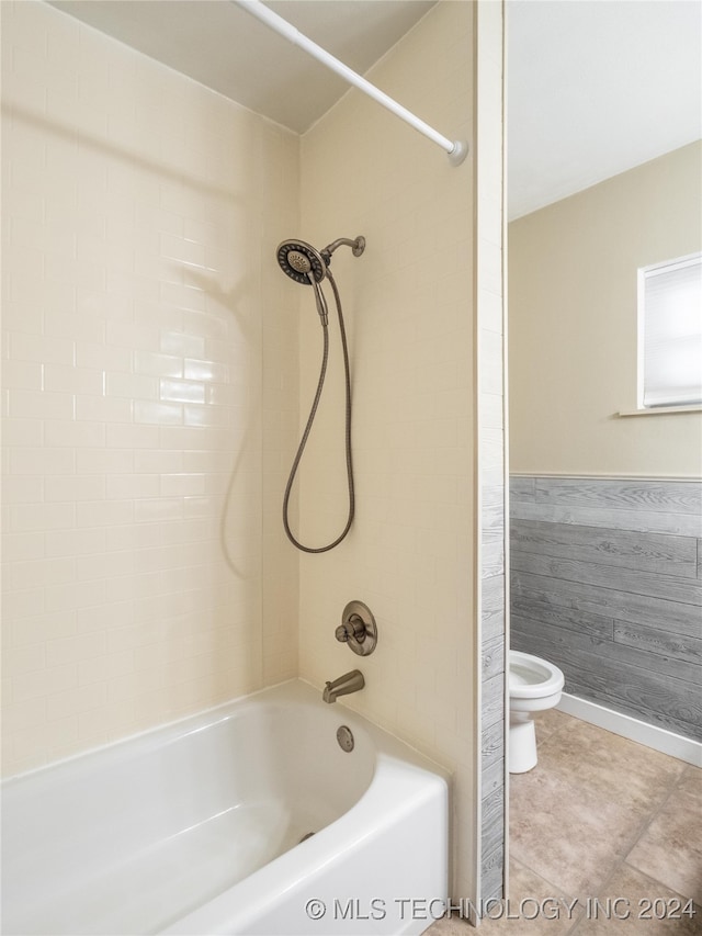 bathroom featuring toilet and tiled shower / bath