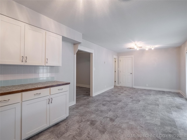 kitchen featuring backsplash and white cabinets