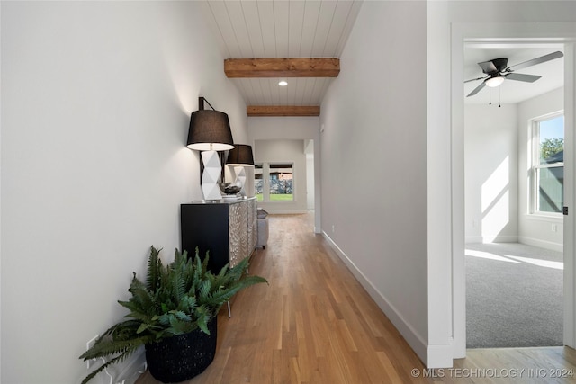 corridor featuring light wood-type flooring, beam ceiling, and wood ceiling