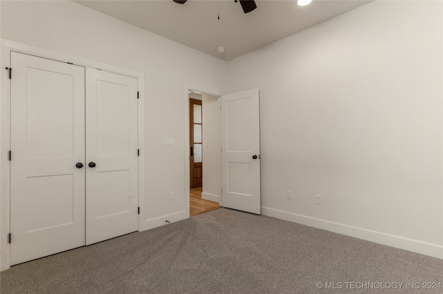 unfurnished bedroom featuring a closet, ceiling fan, and light carpet