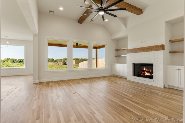 unfurnished living room featuring ceiling fan, vaulted ceiling with beams, built in features, light hardwood / wood-style floors, and a fireplace