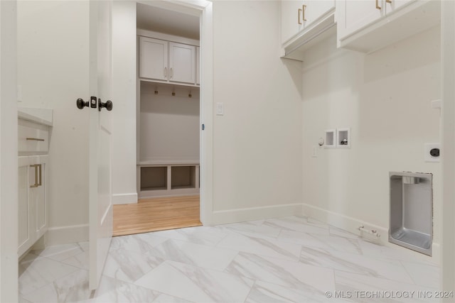 laundry room featuring light hardwood / wood-style floors, electric dryer hookup, washer hookup, and cabinets