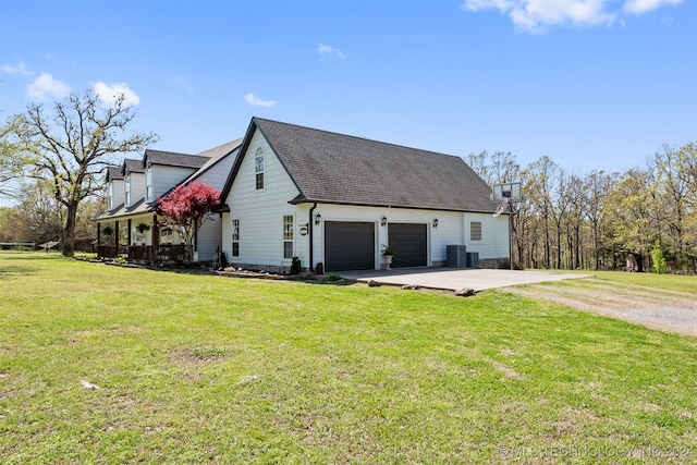 view of property exterior with central AC, a yard, and a garage