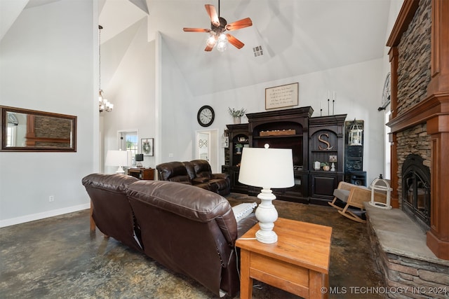 living room featuring ceiling fan with notable chandelier, a stone fireplace, and high vaulted ceiling