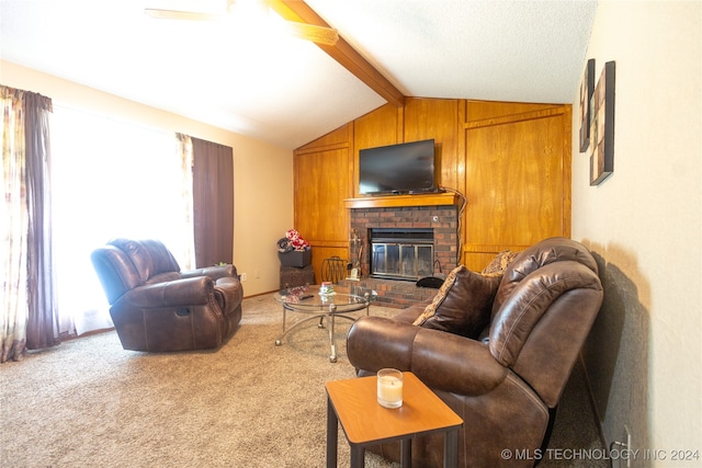 carpeted living room with vaulted ceiling with beams, a fireplace, wood walls, and ceiling fan