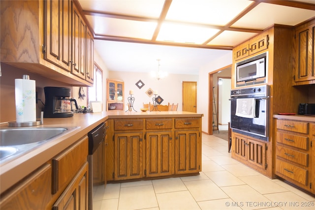 kitchen featuring light tile patterned floors, appliances with stainless steel finishes, kitchen peninsula, and pendant lighting