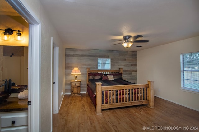 bedroom featuring ceiling fan, wood-type flooring, and sink